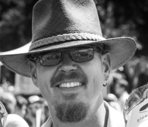 Black and white image of Todd Plymale-Mallory smiling white male.